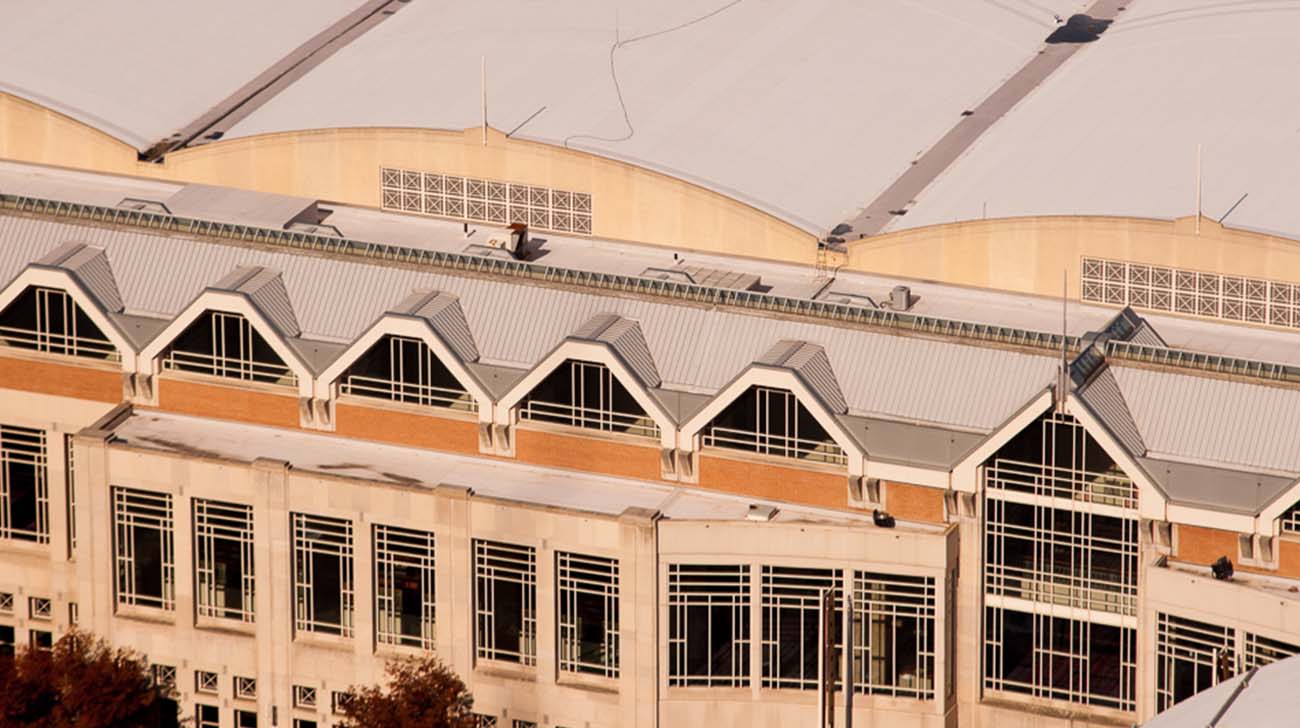Aerial view of a modern building with repeating gabled roof sections and geometric window patterns.